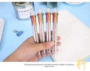 Macro detail of hand holding creative 8-color retractable ballpoint pen with clear barrel