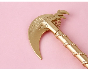 Close-up of golden scythe pen head featuring mystic runes and a spiral textured handle