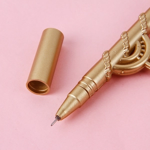 Creative gold scythe neutral pen with embossed metal texture on pink background
