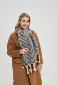 Detail of thick winter scarf with grey zigzag patterns and chunky twisted tassels