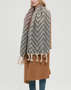 Close-up of thick grey and cream wavy knit scarf with pink accents and chunky tassels