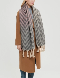 Detail of grey and pink chevron scarf featuring thick tassel knot fringe and soft knit texture