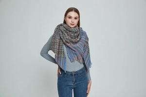Close-up of multi-color plaid scarf featuring soft boucle yarn and fringed edges