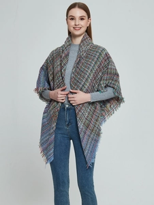 Close-up of multicolored tweed shawl featuring long fringe details and woven texture