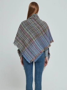 Detail of colorful plaid knit shawl with fringed edges and soft bouclé yarn texture