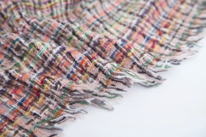 Close-up of multicolor plaid boucle scarf fabric with soft frayed fringe details