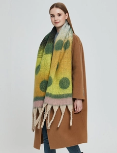 Detailed knit texture of colorful thick winter scarf with large polka dots and tassels