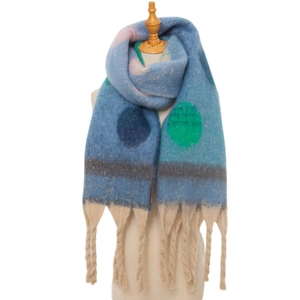 Close-up of thick blue mohair scarf with green polka dots and chunky beige tassels