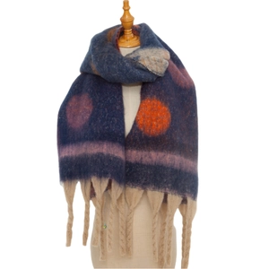 Detail of thick winter scarf with orange polka dots and long beige tassels