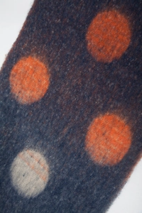 Close-up of thick mohair scarf featuring large orange dots and soft brushed texture