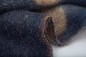 Close-up of thick brushed jacquard fabric with fuzzy texture and soft fringe details
