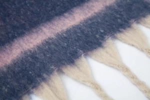 Macro detail of thick tassels and colorful gradient knit on a mohair texture scarf