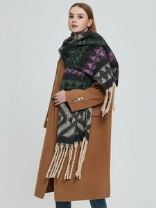 Détail d'une écharpe jacquard à motifs chevrons et longues franges sur un manteau