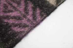 Détail macro d'une écharpe jacquard épaisse à motif de feuilles violettes et texture douce