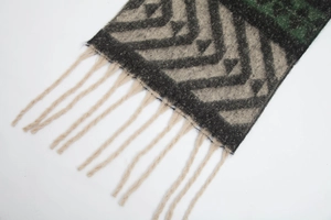 Détail d'une écharpe en maille épaisse avec motifs à chevrons et longues franges