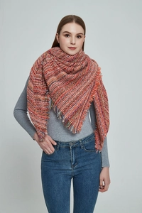 Thick knitted scarf in orange plaid pattern with frayed tassel edges on a female model