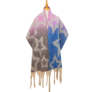 Detailansicht eines dicken Strickschals mit Sternenmuster und langen groben Fransen