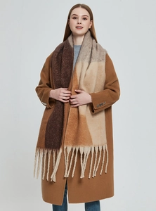 Detail of a thick scarf with geometric brown patterns and long fringes on a model coat