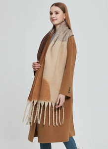 Detailed view of thick knit color block scarf with long fringes and geometric pattern