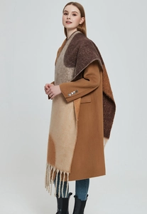 Detail showing thick geometric jacquard pattern and long fringe on the camel scarf