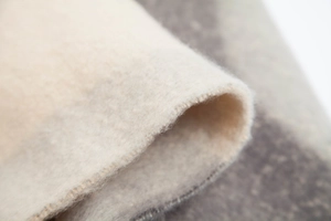 Macro detail of thick geometric jacquard shawl showing plush texture and edge stitching