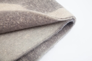 Detailed macro view of gray and cream thick jacquard geometric pattern woven scarf fabric
