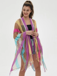 Close-up of rainbow crochet knit shawl with boho fringe trim and open mesh texture