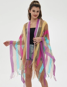 Detail of colorful crochet knit shawl with rainbow stripes and long fringe tassels