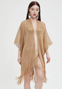 Close-up of golden metallic mesh shawl featuring long fringe details and boho style