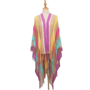Detail of bohemian crochet knit shawl featuring rainbow stripes and long fringe tassels