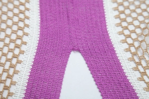 Detailed macro view of the colorful crochet hollow knit pattern and stitching details