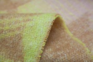 Macro shot of soft brushed star pattern scarf fabric in light brown and neon yellow