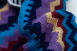 Dettaglio macro del tessuto a maglia zigzag multicolore che mostra trama e motivi ricchi