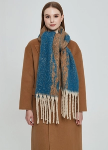 Detail of blue and brown color block winter scarf with thick cream fringe and soft texture