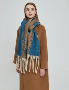 Detailed close-up of thick knit color-block scarf with long beige tassels and soft texture