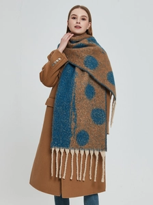 Detail of winter scarf showing navy and brown polka dots with thick beige tassels