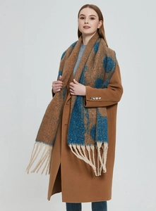 Detail of blue and brown jacquard scarf with thick fringes on a wool coat