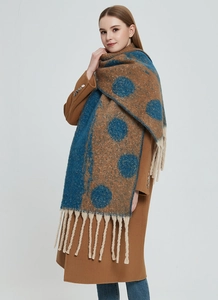 Detail of thick winter scarf with large polka dots and long fringes on wool fabric
