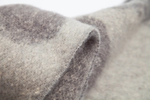 Macro detail of thick grey loop yarn scarf showing soft brushed texture and fringed edges