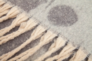 Detail of thick boucle yarn scarf showing soft texture and bicolor polka dot jacquard