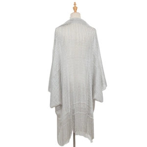 Detail of silver knitted shawl showing shimmering metallic thread and long fringe trim