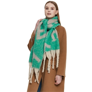 Gros plan sur une écharpe épaisse à motifs abstraits verts avec de longues franges