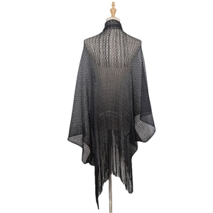 Detail of black hollow knit shawl featuring elegant fringe trim and mesh texture