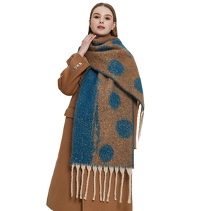 Thick winter scarf with large polka dots and long tassels on camel wool coat