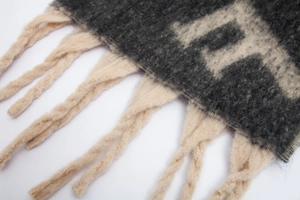 Gros plan détaillé sur le tricot bouclé épais et les franges larges de l'écharpe d'hiver