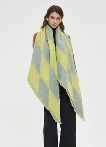 Close-up of diamond pattern scarf with fringe trim in yellow and grey-blue knit fabric