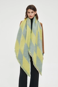Detail of yellow and blue diamond pattern shawl with fringe edges on studio model