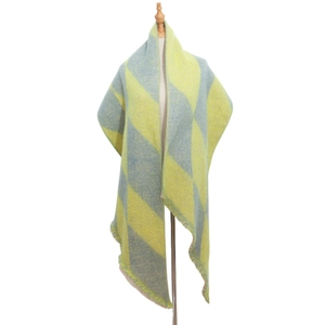Detail of knitted shawl with yellow and grey-blue argyle pattern on a mannequin stand