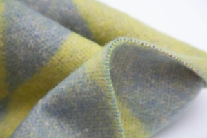Macro detail of soft brushed yellow and blue plaid scarf with refined overlock stitching