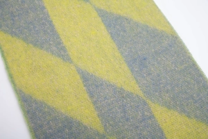 Macro shot of yellow and blue-grey diamond pattern knit fabric with soft brushed texture
